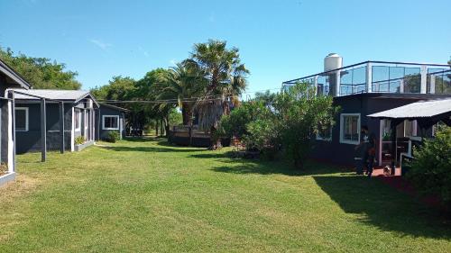 un patio con una casa y una palmera en Complejo Sagitario en Gualeguaychú