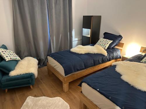 a bedroom with two beds and a chair at Le chalet des étoiles in La Mongie