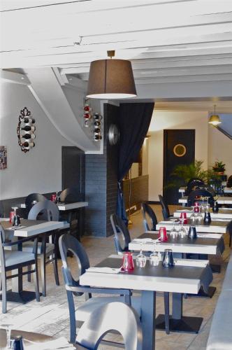 a row of tables and chairs in a restaurant at Hôtel De Paris in Barneville-Carteret