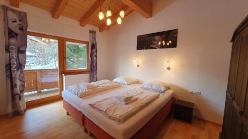 a bedroom with a bed in a room with a window at Haus Carina in Kirchberg in Tirol