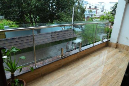 a balcony with a wooden floor and a glass railing at Awesome Property Someone Will Love To Live in Rishīkesh