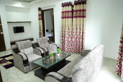 a living room with couches and a table and a tv at Awesome Property Someone Will Love To Live in Rishīkesh