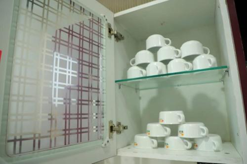 un estante con un montón de tazas y platos blancos en Awsome Property Someone Will Love To Live num001, en Rishīkesh