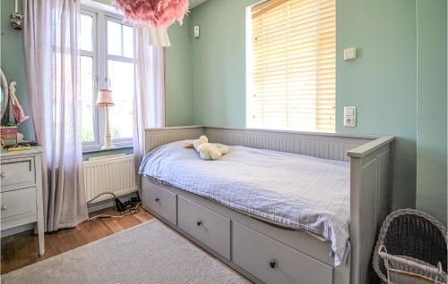 a bedroom with a bed with a teddy bear on it at Awesome Home In Limhamn With House Sea View in Malmö