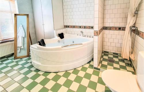 a large tub in a bathroom with a tiled floor at Awesome Home In Limhamn With House Sea View in Malmö