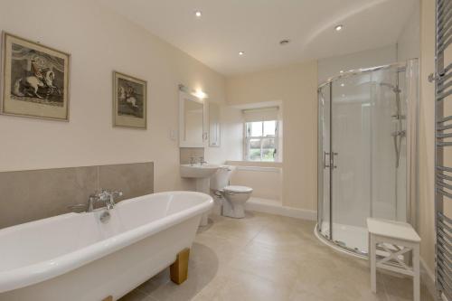 a bathroom with a tub and a shower and a toilet at Pant Farmhouse in Ayr