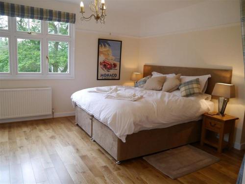 a bedroom with a large bed with white sheets and pillows at Shieling Beag in Banchory