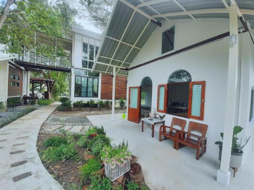 a porch of a house with two chairs and a table at Baangaimuan in Lamphun