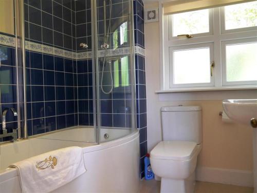 a bathroom with a tub and a toilet and a sink at Shieling Beag in Banchory