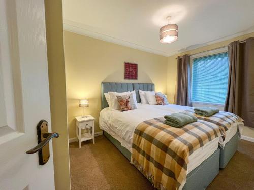 a bedroom with a bed and a window at Creag Dhubh Cottage in Newtonmore