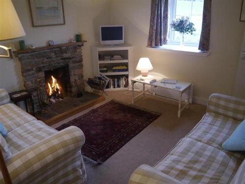 a living room with two couches and a fireplace at Manse Cottage in Elgin