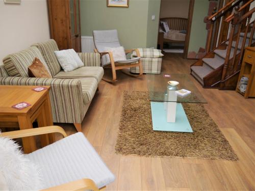 a living room with a couch and a glass table at Laurieknowe Coach House in Dumfries