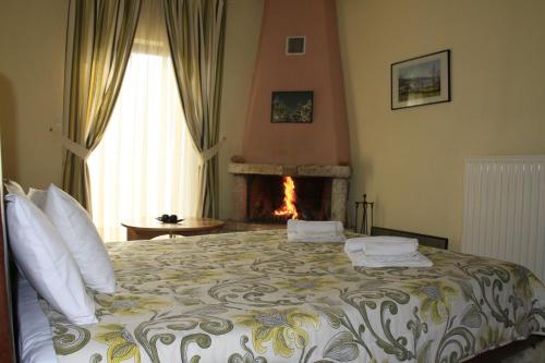 ein Schlafzimmer mit einem Bett und einem Kamin in der Unterkunft Agrafa in Kerasea