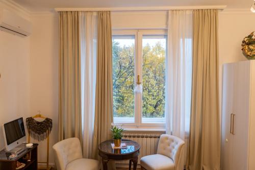 a living room with a table and chairs and a window at GOLDIE in Zagreb