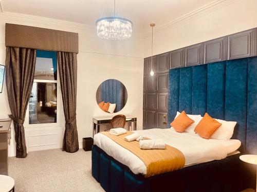 a bedroom with a large bed with a blue headboard at The Lovat Hotel in Perth