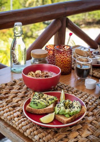 a table with a plate of bread and a bowl of food at El Corazón Boutique Hotel - Adults Only with Beach Club pass included in Holbox Island