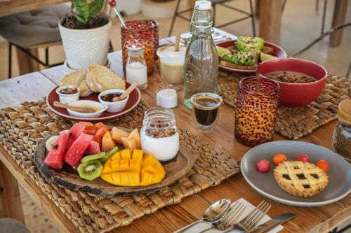 a wooden table with plates of food on it at El Corazón Boutique Hotel - Adults Only with Beach Club pass included in Holbox Island