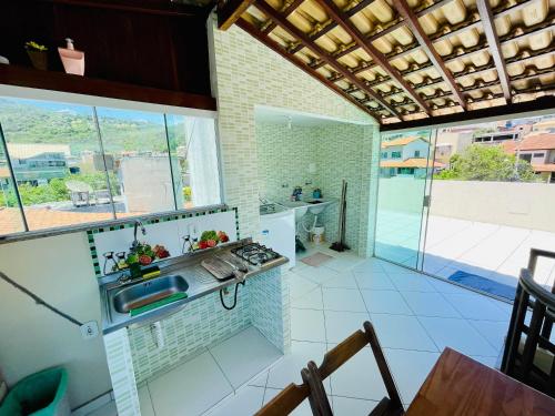 a kitchen with a sink and a stove at Morada do Mar Arraial do Cabo in Arraial do Cabo