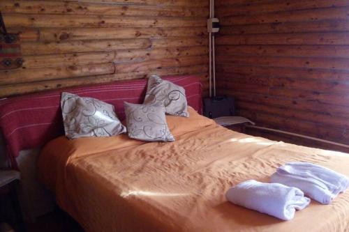 Una cama con dos toallas encima. en Cabaña meolos en Tandil