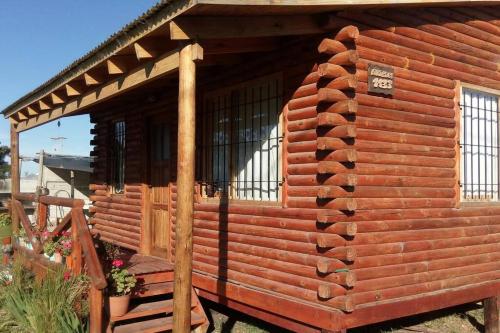 a log cabin with a porch and a deck at Cabaña meolos in Tandil