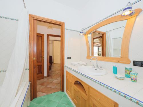 een badkamer met een wastafel en een spiegel bij IL TULIPANO - sea view, roof terrace & sunset in villa in Massa Lubrense