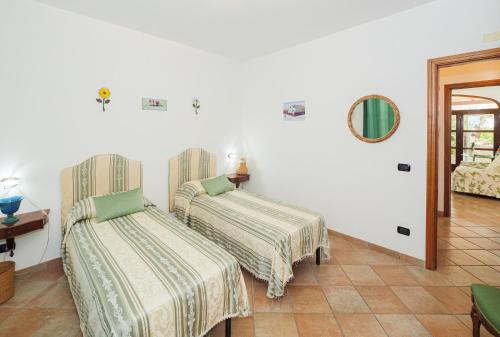 a room with two beds and a mirror on the wall at IL TULIPANO - sea view, roof terrace & sunset in villa in Massa Lubrense