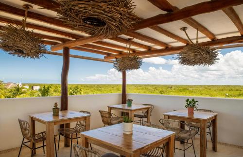 a restaurant with tables and chairs with a view at El Corazón Boutique Hotel - Adults Only with Beach Club pass included in Holbox Island