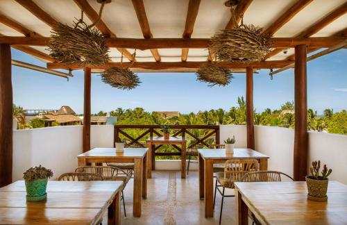 a restaurant with wooden tables and chairs and a balcony at El Corazón Boutique Hotel - Adults Only with Beach Club pass included in Holbox Island
