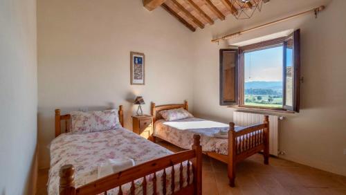 1 dormitorio con 2 camas y ventana en Cortile Del Pozzo, en Buonconvento
