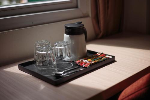a tray with glasses and a coffee maker on a table at Sunstone Hotel in George Town