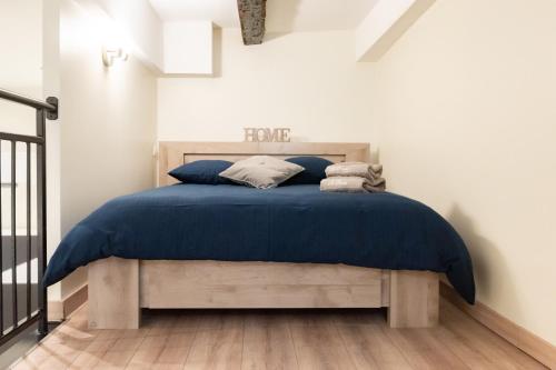een slaapkamer met een bed met een blauw dekbed bij Duplex Ivoire au coeur de Montauban in Montauban