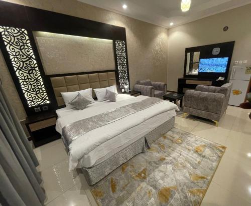 a bedroom with a large bed and a television at Admire Apart' Hotel - Jeddah in Jeddah