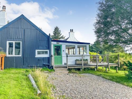 a blue cottage with a green door and a porch at Old Kyle Farm - Stunning Views - 2 mins from Skye Bridge in Kyleakin