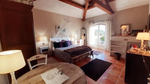 Un dormitorio con una cama y una mesa en una habitación. en Massacan-Vue Mer, en Le Lavandou