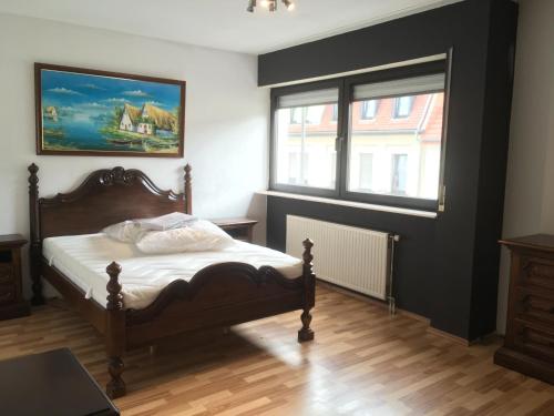 1 dormitorio con 1 cama y una pintura en la pared en MBZ Ferienwohnung TREVERE - 2 ZKB Balkon, en Dillingen an der Saar