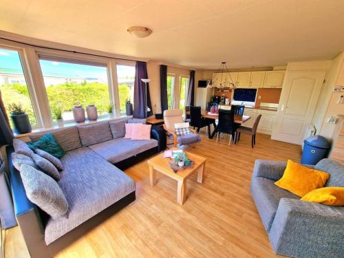 ein Wohnzimmer mit 2 Sofas und einer Küche in der Unterkunft De Corner van Zeeland met jacuzzi in Sint-Annaland