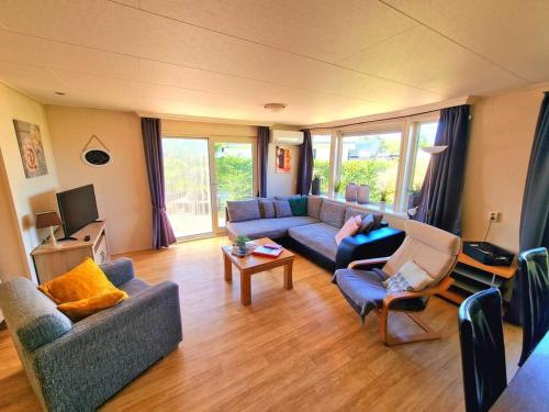 a living room with two couches and a tv at De Corner van Zeeland met jacuzzi in Sint Annaland