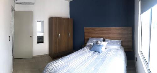 a bedroom with a large bed with blue walls at Hermosos departamentos Ciudad Mayakoba in Playa del Carmen