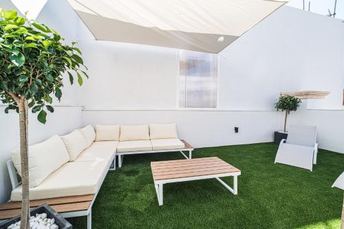 a living room with white furniture and green grass at BOUTIQUE APARTMENTS- LA GLORIA 1908 in Almería