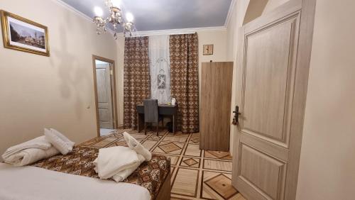 a bedroom with a bed and a door and a table at Deghceni clubhouse in Dilijan