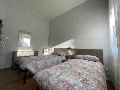 2 łóżka w pokoju z białymi ścianami w obiekcie Appartamento AL PARCO w Padwie