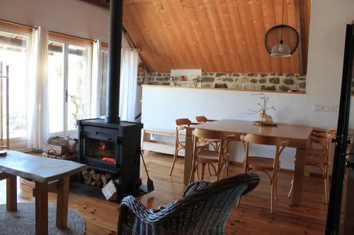 a living room with a wood stove and a table at Le Clou in Thiézac