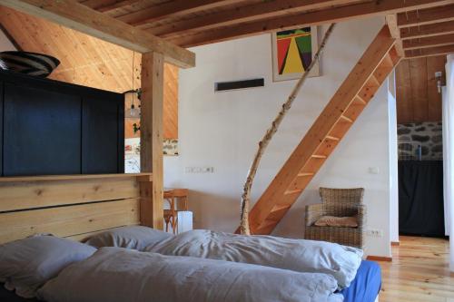 a bed in a room with a wooden ceiling at Le Clou in Thiézac