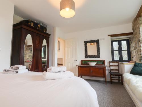 a bedroom with a white bed and a desk at Castle Mill in Newport Pembrokeshire