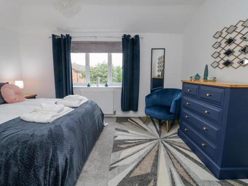 Middlecroft في يورك: غرفة نوم مع خزانة ملابس زرقاء وكرسي أزرق