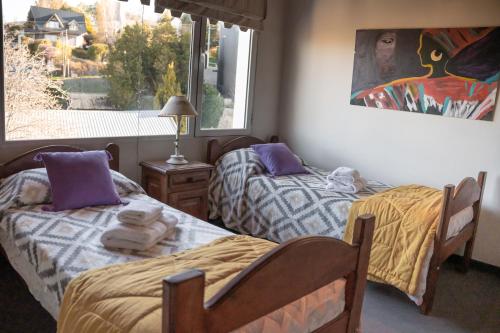 zwei Betten in einem Zimmer mit Fenster in der Unterkunft Departamento Las 3 Marías in San Carlos de Bariloche