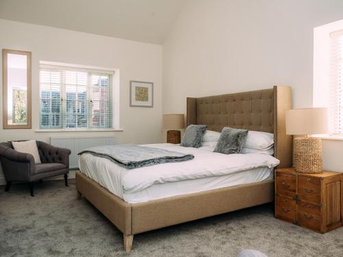 a bedroom with a large bed and a chair at The Groomsmen in Clitheroe