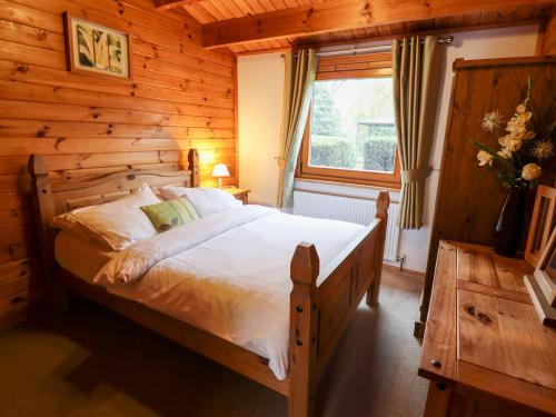 a bedroom with a bed in a log cabin at Avocet Lodge in Lincoln
