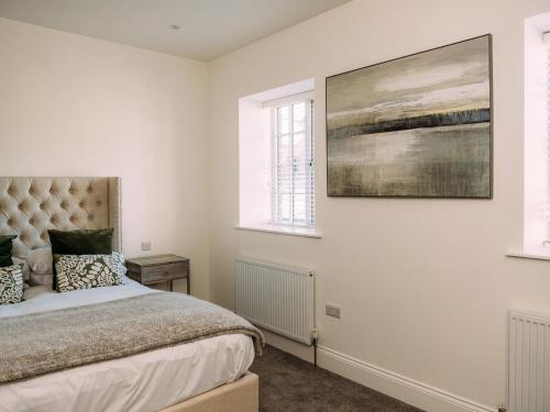 a bedroom with a bed and a painting on the wall at The Gardener in Clitheroe