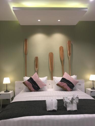 a bedroom with a large white bed with wooden headboards at Snapper House in Khao Lak